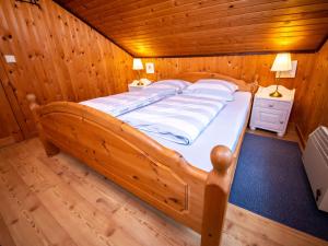 ein Schlafzimmer mit einem Bett in einem Holzzimmer in der Unterkunft Holiday Home Ferienpark Extertal-2 by Interhome in Bremke