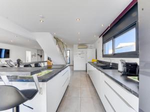 a kitchen with white cabinets and a large window at Holiday Home Norfeu by Interhome in Empuriabrava