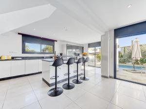 a kitchen with bar stools and a kitchen with a pool at Holiday Home Norfeu by Interhome in Empuriabrava +37 photos