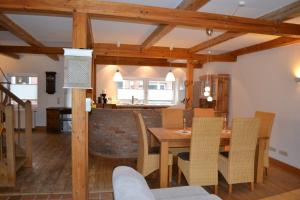 Il comprend une cuisine et une salle à manger avec une table et des chaises en bois. dans l'établissement Ferienhaus Ella, à Tönning