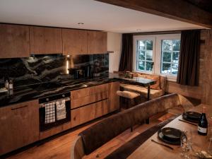 eine Küche mit Holzschränken und einem Tisch mit Stühlen in der Unterkunft Apartment Kirchplatz by Interhome in Zermatt