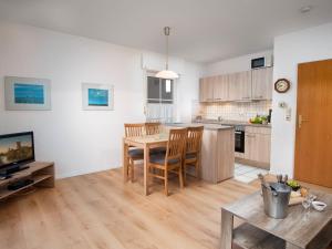 a living room with a dining room table and a kitchen at Apartment Seehund by Interhome in Norddeich