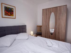 a bedroom with a white bed and a mirror at Apartment Seehund by Interhome in Norddeich