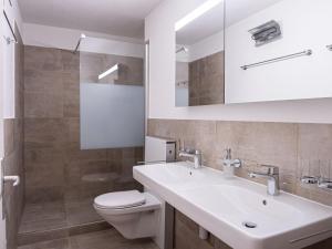 uma casa de banho com um lavatório branco e um WC. em Apartment Chesa Ova Cotschna 306 by Interhome em St. Moritz