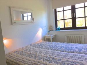- une chambre avec un lit et un miroir mural dans l'établissement Nordseewölckchen 2, à Katingsiel