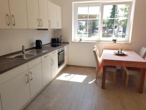 a kitchen with a table and a dining room at Nordergeest EG in Tating