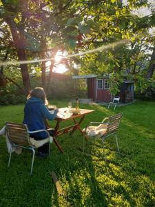 Una donna seduta a un tavolo da picnic in un giardino di Marthas Insel a Oldenswort
