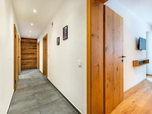 - un couloir avec des murs blancs et des portes en bois dans l'établissement Apartment Leo-3 by Interhome, à Kappl
