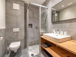 a bathroom with a toilet and a sink and a shower at Apartment Leo-1 by Interhome in Kappl