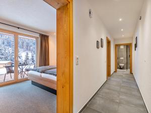 pasillo que conduce a un dormitorio con cama y balcón en Apartment Leo-1 by Interhome, en Kappl