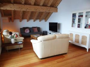 - un salon avec un canapé blanc et une télévision dans l'établissement Apartment Fellenrüti 81 by Interhome, à Engelberg
