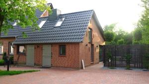 a red brick house with a black roof at Carlotta Studio in Osterhever