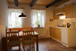 a kitchen with a table and chairs in a room at FW auf dem Land in Garding
