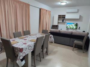 uma sala de jantar com uma mesa e cadeiras e uma cama em Dolphin Court 3-Bedroom Sea View Apartment in Marsaskala, Malta em Marsaskala