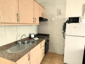 una piccola cucina con lavello e frigorifero di Magic Conch Holiday Home a Playa del Ingles Altre 15 foto