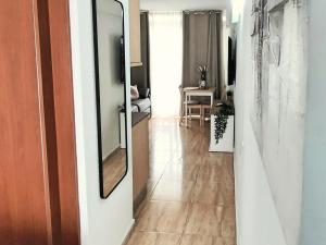 un soggiorno con specchio e corridoio di Magic Conch Holiday Home a Playa del Ingles