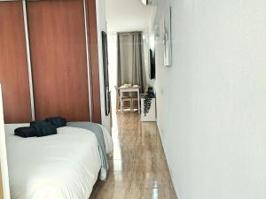 una camera con letto e un corridoio con tavolo di Magic Conch Holiday Home a Playa del Ingles