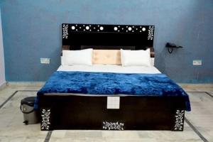 ein Schlafzimmer mit einem großen Bett mit blauer Wand in der Unterkunft Hotel Pink Haveli in Jaipur