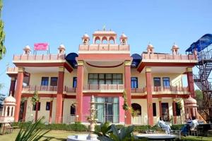 ein großes rosafarbenes Gebäude mit vielen Fenstern in der Unterkunft Hotel Pink Haveli in Jaipur
