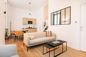 a living room with a couch and a table at Le Laurencin Sens - La Mezzanine - Cœur de ville in Sens