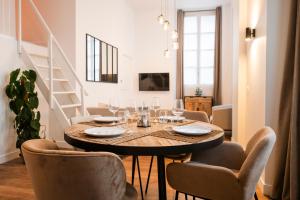 comedor con mesa de madera y sillas en Le Laurencin Sens - La Mezzanine, en Sens