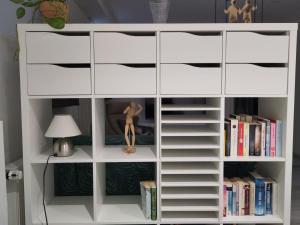 a white book shelf with a mannequin in the middle at Casa Viva - Separate, ruhig gelegene Wohnung in Quierschied