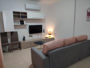 a living room with a couch and a flat screen tv at Dolphin Court 3-Bedroom Sea View Apartment in Marsaskala, Malta in Marsaskala