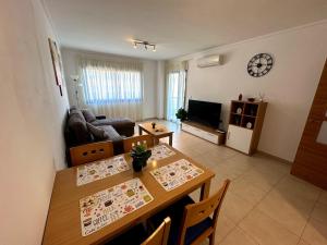 a living room with a dining room table and a living room with a table at Alicante Hills Luxury Beach Apartment in Alicante