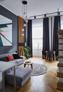 華沙的住宿－Stylish Apart with Mezzanine and Balcony by ECRU WWA60，客厅配有沙发和桌子
