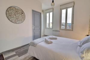 sypialnia z dużym białym łóżkiem i lustrem w obiekcie Appart du Pont Vert A12 proche centre - Mon Groom w Troyes