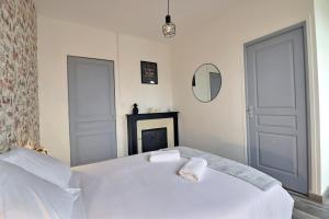 sypialnia z białym łóżkiem i lustrem w obiekcie Appart du Pont Vert A12 proche centre - Mon Groom w Troyes