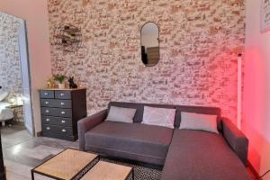 uma sala de estar com um sofá e uma parede rosa em Appart du Pont Vert A12 proche centre - Mon Groom em Troyes