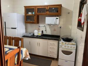 een kleine keuken met een fornuis en een koelkast bij apartamento águas de lindoia itaigara in Águas de Lindóia