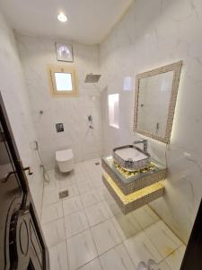 La salle de bains blanche est pourvue d'un lavabo et de toilettes. dans l'établissement منتزة درة العروس, à Taif
