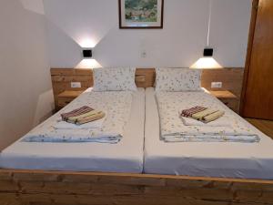 two beds in a small bedroom with two lamps at Holiday Home Oberhaus by Interhome in Finkenberg