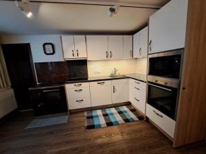 a kitchen with white cabinets and black appliances at Holiday Home Oberhaus by Interhome in Finkenberg