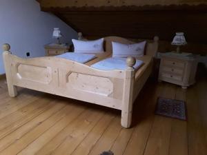 1 dormitorio con 1 cama de madera y 2 mesitas de noche en Ferienhäuser zum Badeweiher, en Neuschönau