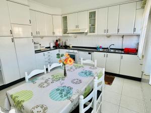 a kitchen with a table with a vase of flowers on it at CASA GLORIA in Combarro