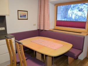 einen Tisch und Stühle in einem Zimmer mit Fenster in der Unterkunft Apartment Hedwig Jäger - KPL420 by Interhome in Kappl