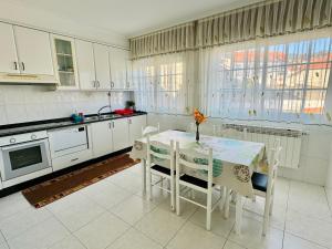 a kitchen with a table and chairs and a kitchen with white cabinets at CASA GLORIA in Combarro