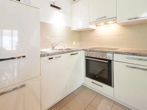 una cocina con armarios blancos y fregadero en Apartment Grives by Interhome, en Les Collons