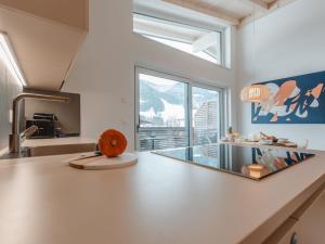 a kitchen with a large white counter and a large window at Apartment Das Georgen- Kitzsteinhorn by Interhome in Fürstau