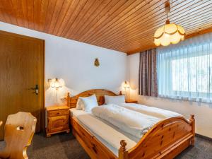 sypialnia z drewnianym łóżkiem i oknem w obiekcie Apartment Sailer - KPL321 by Interhome w mieście Kappl
