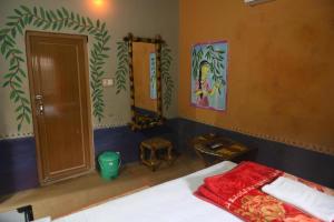 a bedroom with a bed and a mirror and a door at Ram Shyam Village Resort in Shānti Niketan