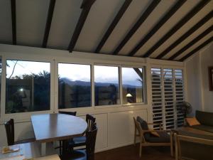 a living room with a table and some windows at Gîtes KUMQUAT in Petit-Bourg