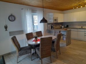 a kitchen and dining room with a table and chairs at Holiday Home Sanddorn by Interhome in Altefähr