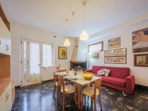 un soggiorno con tavolo e divano rosso di Apartment Ilaria by Interhome a Marina di Massa