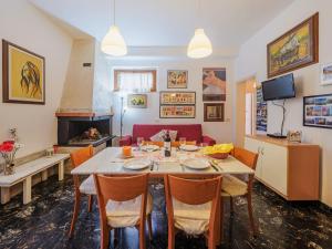 una sala da pranzo con tavolo, sedie e divano di Apartment Ilaria by Interhome a Marina di Massa