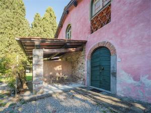 uma casa cor-de-rosa com uma porta verde e um pátio em Apartment Le Fornaci-1 by Interhome em San Quirico di Moriano