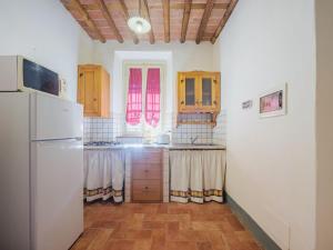 San Quirico di MorianoにあるApartment Le Fornaci-1 by Interhomeのキッチン(白い冷蔵庫、木製キャビネット付)